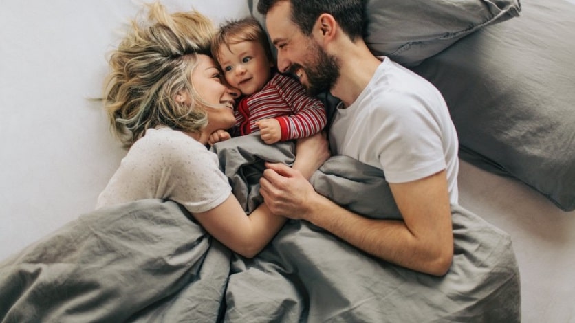 cojeune couple avec enfant dans un lit